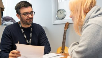 Man with glasses talking to young woman with blonde hair