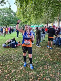 Woman posing with medal after running a marathon.