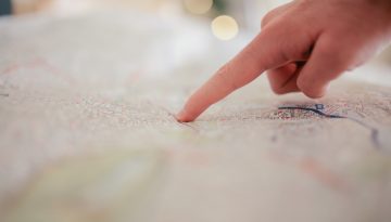 Hand pointing at a map
