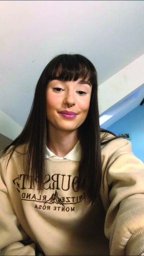 Amelia, a young woman with long dark hair in a beige sweatshirt
