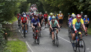 Group of cyclists riding cylcling along a country road