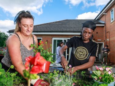 Young person and support worker gardening