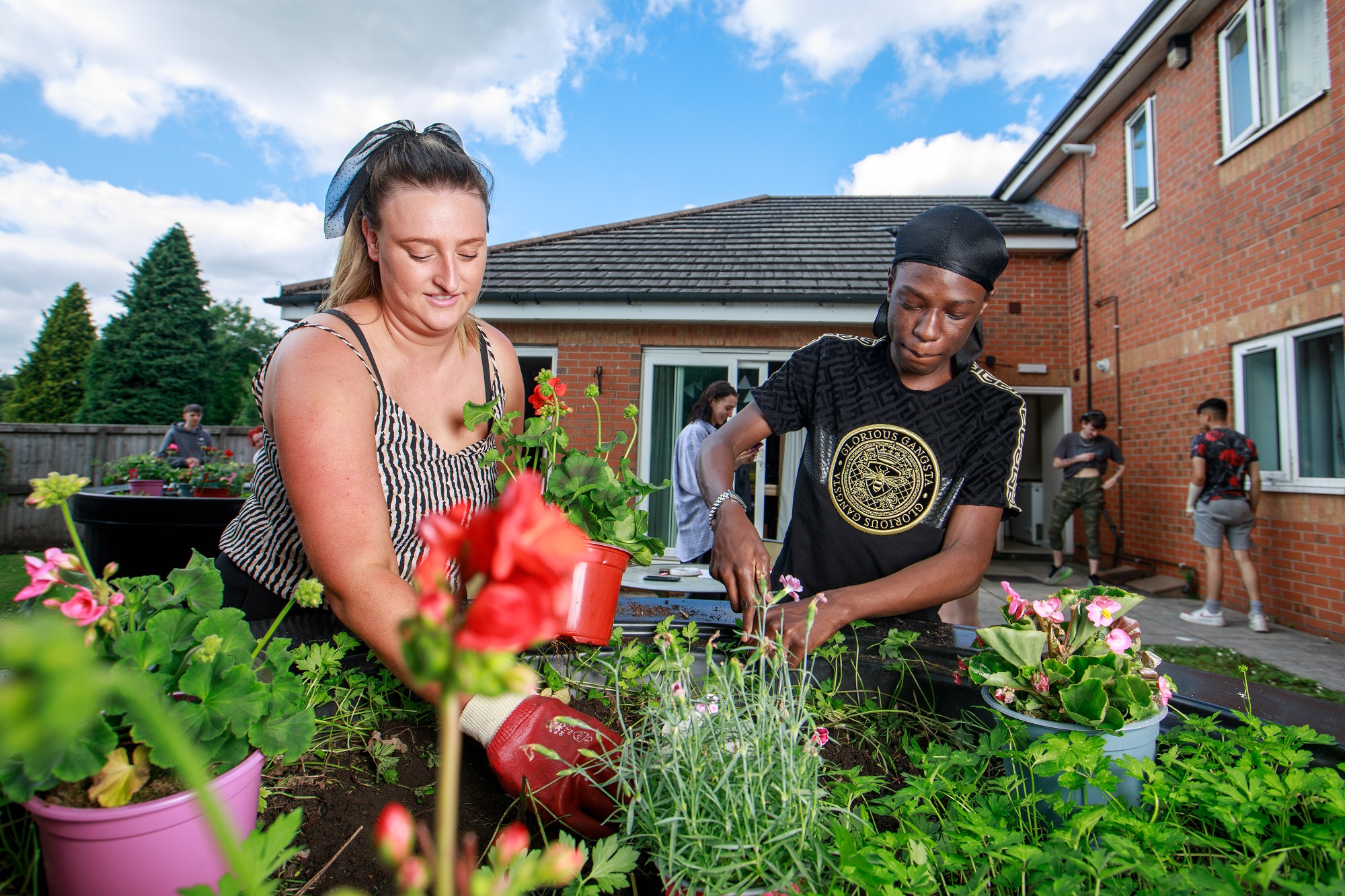 Young person and support worker gardening