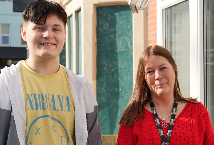 Depaul staff and young person standing outside a house smiling