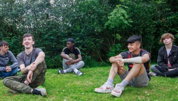 Group of young men sat on the grass