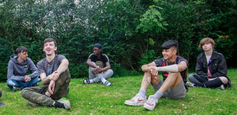 Group of young men sat on the grass