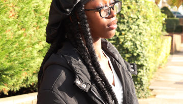 Young person standing in the street looking pensive