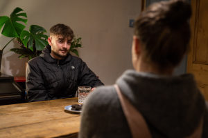 Young person with Nightstop host sat at kitchen table