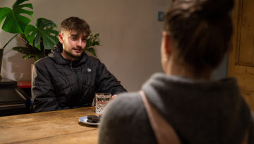 Young person with Nightstop host sat at kitchen table