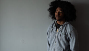 young man standing by a wall