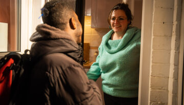 Volunteer host opening the door to a young person