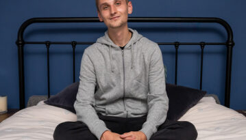 Young person on a bed smiling looking content