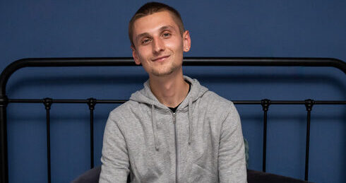 Young person on a bed smiling looking content