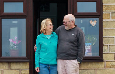 Hosts smiling at their front door.