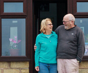 Hosts smiling at their front door.
