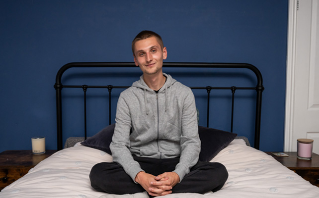 Young male called Jamie sitting on a bed