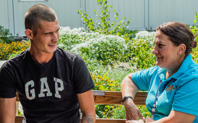 Two people talking in a garden