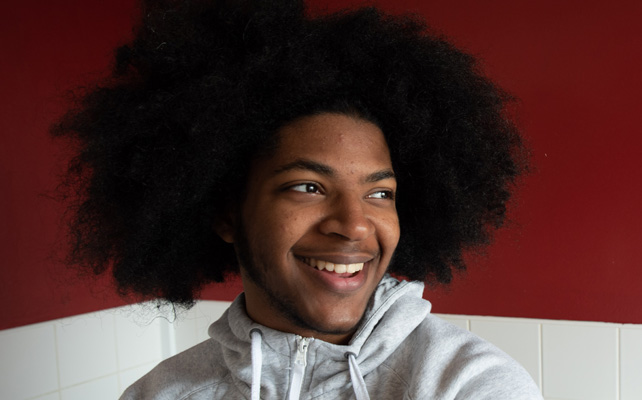Man smiling against red wall