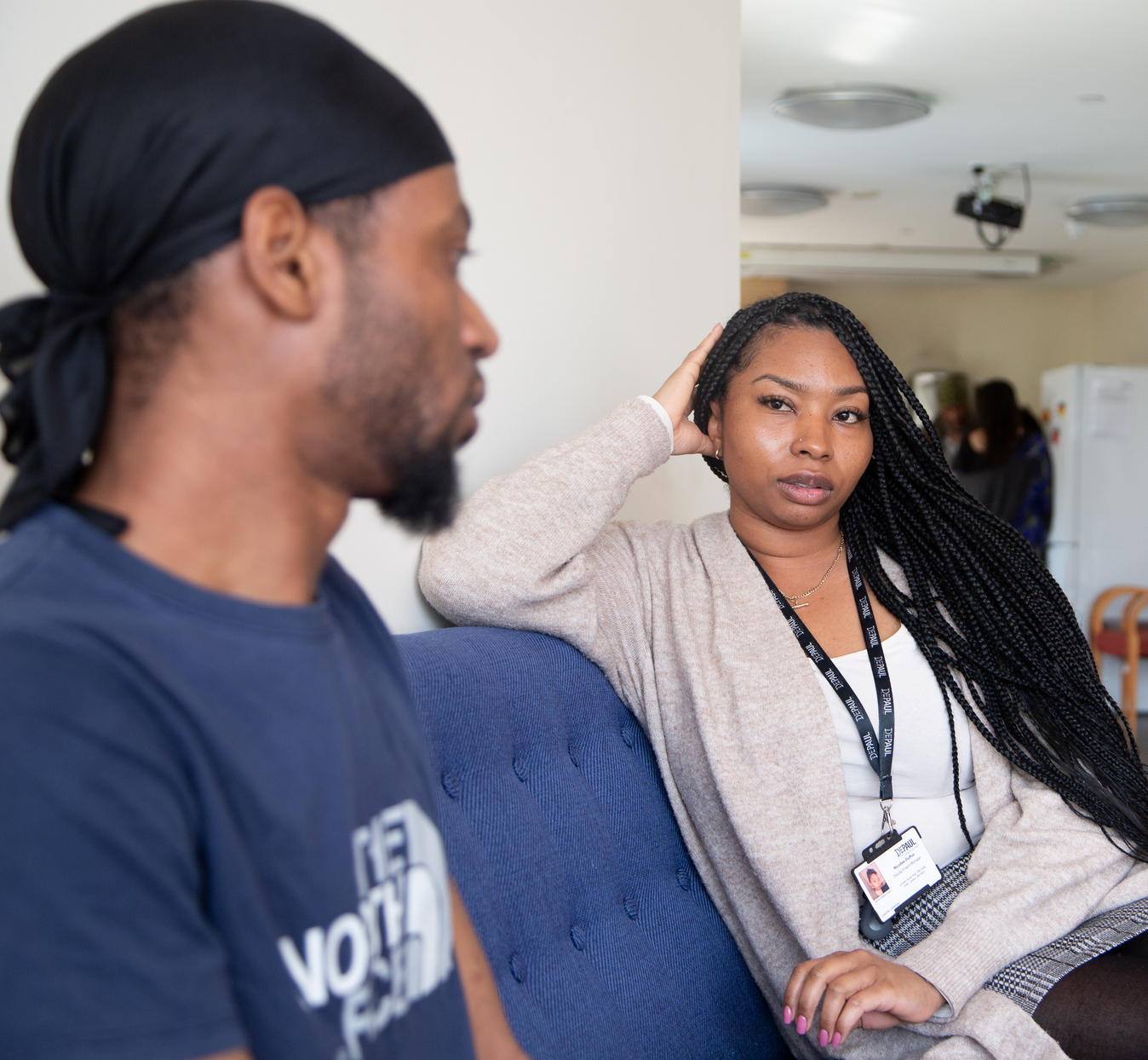 Staff and young person chatting on a sofa at a service.