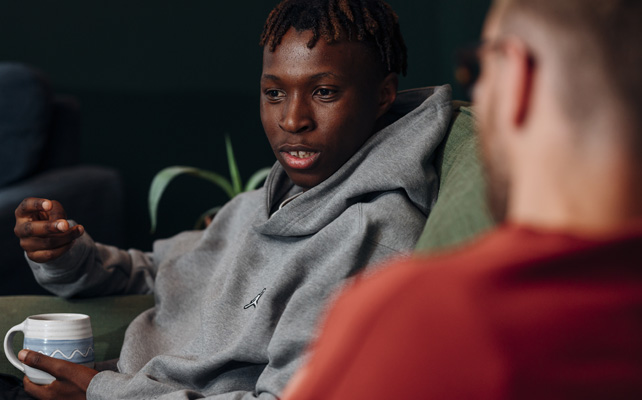Two people talking on a sofa