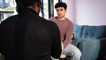 Young person Mo and Nightstop host sat at kitchen table