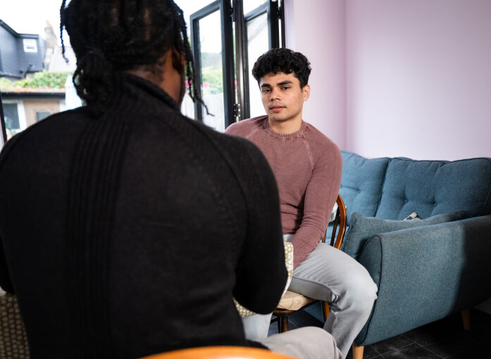 Young person Mo and Nightstop host sat at kitchen table