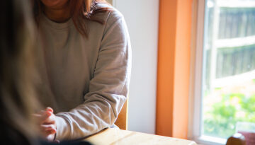 hands and shoulder of a woman talking to someone