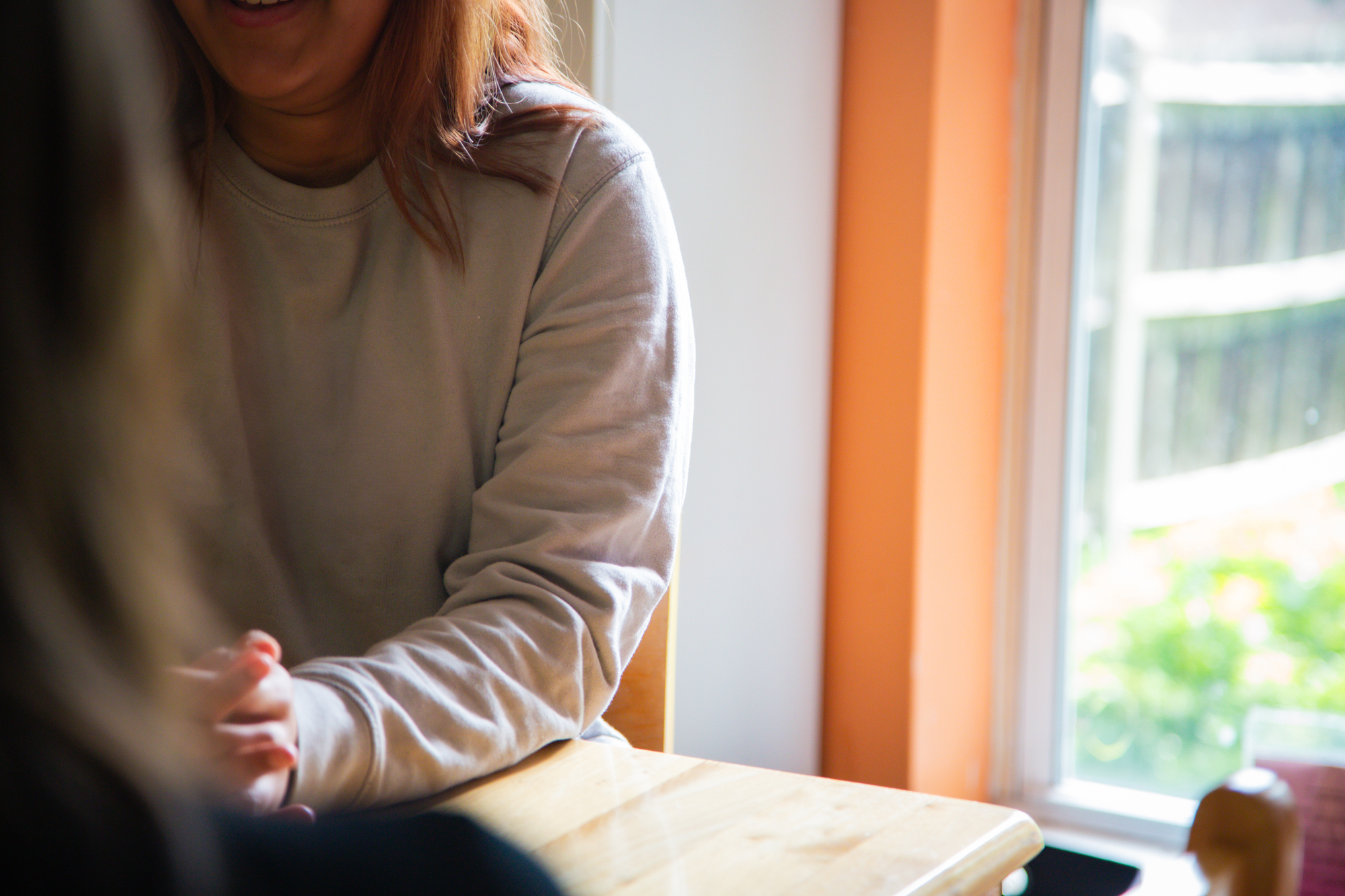 hands and shoulder of a woman talking to someone