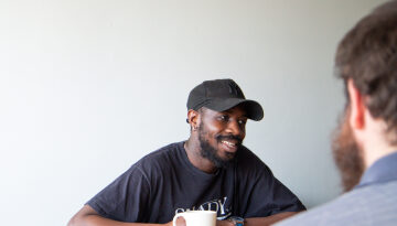Depaul UK staff member smiling talking to a young person with their back to the camera