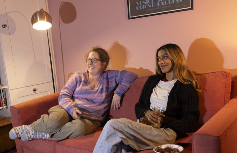 Kassi and host sitting on the sofa watching TV.